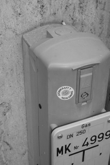 Pfosten, mit Schild zur Gasversorgung an einer Hauswand, schwarz-weiß